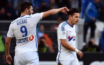 Marseille's French midfielder Florian Thauvin (R) is gongratulated by Marseille's French forward Andre-Pierre Gignac  after scoring a goal during the French L1 football match Marseille (OM) vs Lille (LOSC) on December 21, 2014 at the Velodrome stadium in Marseille, southeastern France. AFP PHOTO / ANNE-CHRISTINE POUJOULAT        (Photo credit should read ANNE-CHRISTINE POUJOULAT/AFP via Getty Images)