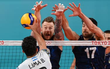 (L-R) Argentina's Bruno Lima hits the ball in front of Italy's Ivan Zaytsev and Simone Anzani in the men's quarter-final volleyball match between Italy and Argentina during the Tokyo 2020 Olympic Games at Ariake Arena in Tokyo on August 3, 2021. (Photo by YURI CORTEZ / AFP) (Photo by YURI CORTEZ/AFP via Getty Images)