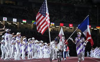 epa09449206 A handout photo made available by OIS/IOC shows Flag Bearer Matt Scott USA carrying his national flag ahead of Flag Bearer Alexandre Leaute FRA in the Olympic Stadium during the Closing Ceremony for the Tokyo 2020 Paralympic Games, Tokyo, Japan, Sunday 05 September 2021.  EPA/Thomas Lovelock for OIS HANDOUT   EDITORIAL USE ONLY/NO SALES