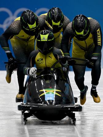 19 February 2022, China, Yanqing: Bobsleigh, Olympics, four-man bobsleigh, men, heat 2, at the National Sliding Centre, Jamaica's Shanwayne Stephens (front) takes off with his teammates. Photo: Robert Michael/dpa-Zentralbild/dpa (Photo by Robert Michael/picture alliance via Getty Images)