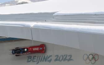 17 February 2022, China, Yanqing: Olympics, bobsleigh, four-man bobsleigh, training, men at the National Sliding Centre, bobsleigh pilot Patrick Baumgartner from Italy in action. Photo: Robert Michael/dpa-Zentralbild/dpa