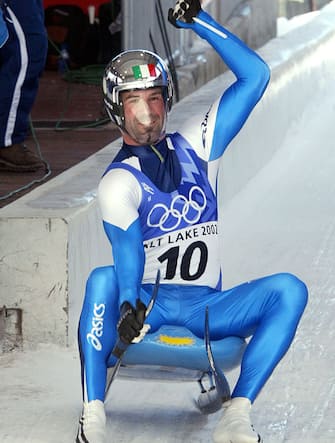Italian Armin Zoeggeler celebrates after winning the men's single luge event of the Salt Lake 2002 Olympic Winter Games at the Utah Olympic Park, 11 February 2002, in Park City, Utah. Zoeggeler took the gold medal, German Georg Hackl the silver medal and Austrian Markus Prock the bronze.AFP PHOTO  KAZUHIRO NOGI (Photo by Kazuhiro NOGI / AFP)        (Photo credit should read KAZUHIRO NOGI/AFP via Getty Images)