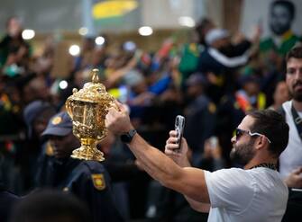 epa10950300 Springbok rugby team player Cobus Reinach poses with the William Webb Ellis Cup upon the team's arrival in the country after winning the 2023 Rugby World Cup, in Johannesburg, South Africa, 31 October 2023. The Springboks won back to back Rugby World Cups and are the only team to have won four titles. They will embark on a trophy tour around the country starting 02 November.  EPA/KIM LUDBROOK