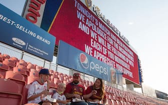 SANDY, UT -  AUGUST 26: Fans finish their dinner as the digital scoreboard above them alerts that the game between Real Salt Lake and the Los Angeles FC was postponed at Rio Tinto Stadium on August 26, 2020 in Sandy, Utah. Several sporting leagues across the nation today are postponing their schedules as players protest the shooting of Jacob Blake by Kenosha, Wisconsin police. (Photo by Chris Gardner/Getty Images)