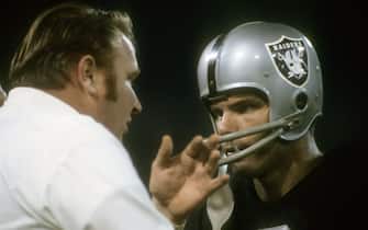 OAKLAND, CA - CIRCA 1970:  Quarterback Daryle Lamonica #3 of the Oakland Raiders talks with head coach John Madden on the sidelines during an NFL football game circa 1970 at the Oakland Coliseum in Oakland, California. Lamonica played for the Raiders from 1967-74. (Photo by Focus on Sport/Getty Images)