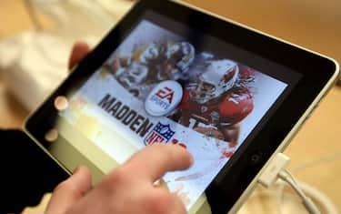A shopper tries out a Madden NFL video game on an iPad at Apple Inc.'s flagship store on Fifth Avenue in New York, U.S., on Saturday, April 3, 2010. With the iPad, Apple bets it can succeed where rivals such as Microsoft Corp. failed: building a following for a device that's bigger than a mobile phone, yet has fewer features than a laptop. Photographer: Jin Lee/Bloomberg via Getty Images