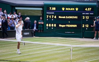 1169816235 LONDON, ENGLAND - JULY 14: Novak Djokovic of Serbia in front of the scoreboard after defeating Roger Federer of Switzerland (not pictured) during the Men's Singles Final at The Wimbledon Lawn Tennis Championship at the All England Lawn and Tennis Club at Wimbledon on July 14, 2019 in London, England. (Photo by Simon Bruty/Anychance/Getty Images)