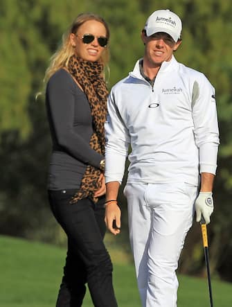 DUBAI, UNITED ARAB EMIRATES - FEBRUARY 07:  Rory McIlroy of Northern Ireland with his girlfriend Caroline Wozniacki of Denmark the World's Number One female tennis player during his practice round as a preview for the 2012 Omega Dubai Desert Classic on the Majilis Course at the Emirates Golf Club on February 7, 2012 in Dubai, United Arab Emirates.  (Photo by David Cannon/Getty Images)
