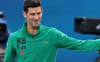 Serbia's Novak Djokovic is wearing a jacket with Kobe Bryant initials talks to a kid prior to his men's singles quarter-final match against Canada's Milos Raonic on day nine of the Australian Open tennis tournament in Melbourne on January 28, 2020. (Photo by DAVID GRAY / AFP) / IMAGE RESTRICTED TO EDITORIAL USE - STRICTLY NO COMMERCIAL USE (Photo by DAVID GRAY/AFP via Getty Images)