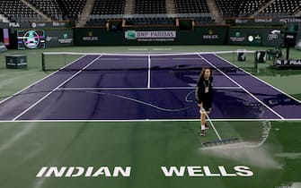 INDIAN WELLS, CALIFORNIA - MARCH 08:  Courtmaster Jeffrey Brooker cleans the center court at the Indian Wells Tennis Garden on March 08, 2020 in Indian Wells, California. The BNP Paribas Open was cancelled by the Riverside County Public Health Department, as county officials declared a public health emergency when a case of coronavirus (COVID-19) was confirmed in the area. (Photo by Matthew Stockman/Getty Images)