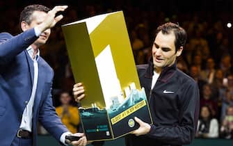 epa06533811  Roger Federer of Switzerland receives a trophy for getting the highest ranking again at the ATP after winning from  Robin Haase of the Netherlands in their quarter final match of the ABN AMRO World Tennis Tournament in Rotterdam, Netherlands, 16 February 2018.  EPA/KOEN SUYK