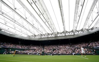Jack Draper serves to Novak Djokovic on centre court on day one of Wimbledon at The All England Lawn Tennis and Croquet Club, Wimbledon. Picture date: Monday June 28, 2021.