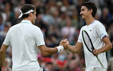 Italy's Lorenzo Sonego (R) shakes hands after losing to Switzerland's Roger Federer during their men's singles fourth round match on the seventh day of the 2021 Wimbledon Championships at The All England Tennis Club in Wimbledon, southwest London, on July 5, 2021. - RESTRICTED TO EDITORIAL USE (Photo by Glyn KIRK / AFP) / RESTRICTED TO EDITORIAL USE (Photo by GLYN KIRK/AFP via Getty Images)