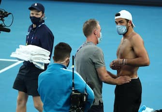epa09008537 Matteo Berrettini of Italy (R) receives medical treatment as he plays Karen Khachanov of Russia during their third round match at the Australian Open Grand Slam tennis tournament in Melbourne, Australia, 13 February 2021. The Australian Open will proceed for five days with no fans after the state of Victoria was placed on lockdown to contain a new COVID-19 outbreak.  EPA/JASON O'BRIEN