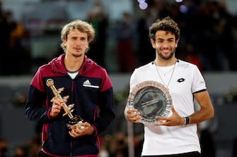 epa09188451 Alexander Zverev (L) of Germany celebrates with his trophy after winning against Matteo Berrettini (R) of Italy during the Men's final match at the Mutua Madrid Open tennis tournament in Madrid, Spain, 09 May 2021.  EPA/CHEMA MOYA