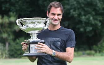epa06482952 Roger Federer (C) of Switzerland stands with the Australian Open Trophy, also known as the Norman Brookes Challenge Cup, at government House in Melbourne, Victoria, Australia, 29 January 2018. Federer has become the first man to claim 20 grand slam singles titles after winning the Australian Open final for a record-equalling sixth time.  EPA/DAVID CROSLING  AUSTRALIA AND NEW ZEALAND OUT