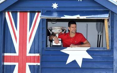 epa09028953 Novak Djokovic of Serbia poses for photographs while standing in a beach shack on Brighton Beach with the Norman Brookes Challenge Cup following his men's singles finals win against Daniil Medvedev of Russia at the Australian Open grand slam tennis tournament, in Melbourne, Australia, 22 February 2021.  EPA/DAVE HUNT AUSTRALIA AND NEW ZEALAND OUT