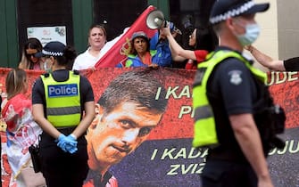 People hold placards up at a government detention centre where Serbia's tennis champion Novak Djokovic is reported to be staying in Melbourne on January 7, 2022, after Australia said it had cancelled the entry visa of Djokovic, opening the way to his detention and deportation in a dramatic reversal for the tennis world number one. (Photo by William WEST / AFP) (Photo by WILLIAM WEST/AFP via Getty Images)