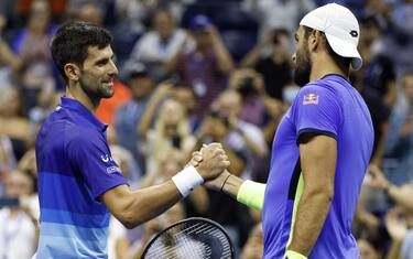 epa09456713 Novak Djokovic of Serbia (L) shakes hands with Matteo Berrettini of Italy after defeating him during their quarterfinals round match on the tenth day of the US Open Tennis Championships at the USTA National Tennis Center in Flushing Meadows, New York, USA, 08 September 2021. The US Open runs from 30 August through 12 September.  EPA/JASON SZENES