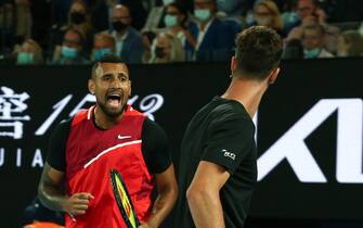 Australia's Nick Kyrgios (L) and compatriot Thanasi Kokkinakis react as they play against Australia's Matthew Ebden and compatriot Max Purcell during their men's doubles final match on day thirteen of the Australian Open tennis tournament in Melbourne on January 29, 2022. - -- IMAGE RESTRICTED TO EDITORIAL USE - STRICTLY NO COMMERCIAL USE -- (Photo by Aaron FRANCIS / AFP) / -- IMAGE RESTRICTED TO EDITORIAL USE - STRICTLY NO COMMERCIAL USE -- (Photo by AARON FRANCIS/AFP via Getty Images)