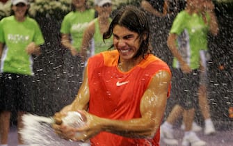 MADRID, Spain:  Spain's Rafael Nadal sprays champagne around after winning the Men's singles final of the Madrid masters tennis tournament in Madrid, 23 October 2005. Nadal beat Croatia's Ivan Ljubicic, 3-6, 2-6, 6-3, 6-4, 7-6. AFP PHOTO/PIERRE-PHILIPPE MARCOU  (Photo credit should read PIERRE-PHILIPPE MARCOU/AFP via Getty Images)