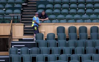 Workers in the royal box watch as Rafael Nadal and Matteo Berrettini practice on centre court ahead of the 2022 Wimbledon Championship at the All England Lawn Tennis and Croquet Club, Wimbledon. Picture date: Thursday June 23, 2022.