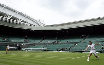 Novak Djokovic (left) and Marin Cilic practice on centre court ahead of the 2022 Wimbledon Championship at the All England Lawn Tennis and Croquet Club, Wimbledon. Picture date: Thursday June 23, 2022.
