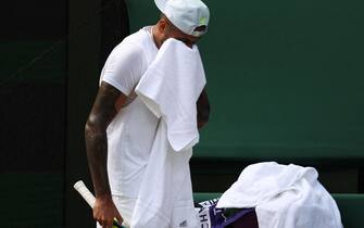 Australia's Nick Kyrgios wipes his face as he plays against Serbia's Novak Djokovic during their men's singles final tennis match on the fourteenth day of the 2022 Wimbledon Championships at The All England Tennis Club in Wimbledon, southwest London, on July 10, 2022. - RESTRICTED TO EDITORIAL USE (Photo by Adrian DENNIS / AFP) / RESTRICTED TO EDITORIAL USE (Photo by ADRIAN DENNIS/AFP via Getty Images)