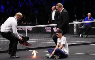 A protester lights a fire on the court on day one of the Laver Cup at the O2 Arena, London. Picture date: Friday September 23, 2022.