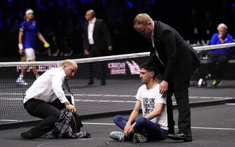Steward remove a protester after setting fire to the court on day one of the Laver Cup at the O2 Arena, London. Picture date: Friday September 23, 2022.