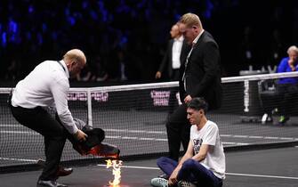 A protester lights a fire on the court on day one of the Laver Cup at the O2 Arena, London. Picture date: Friday September 23, 2022.