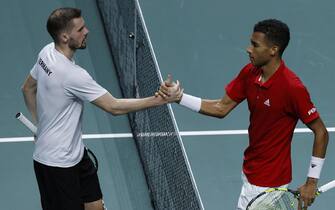 epa10326298 Canada's Felix Auger-Aliassime (R) is congratulated by Germany's Oscar Otte (L) after their match of the Davis Cup finals' quarter-finals between Germany and Canada in Malaga, southern Spain, 24 November 2022.  EPA/JULIO MUNOZ