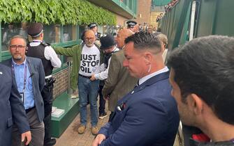 Just Stop Oil protesters are searched away by Police after throwing orange confetti on court 18 on day three of the 2023 Wimbledon Championships at the All England Lawn Tennis and Croquet Club in Wimbledon. Picture date: Wednesday July 5, 2023.