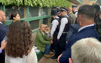 Just Stop Oil protesters are detained by Police after throwing orange confetti on court 18 on day three of the 2023 Wimbledon Championships at the All England Lawn Tennis and Croquet Club in Wimbledon. Picture date: Wednesday July 5, 2023.