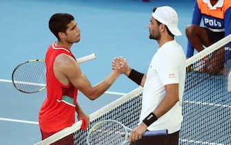 epa09699334 Matteo Berrettini of Italy (R) shakes hands with Carlos Alcaraz of Spain after winning their third round match at the Australian Open Grand Slam tennis tournament in Melbourne, Australia, 21 January 2022.  EPA/JASON O'BRIEN