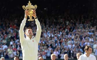 epaselect epa04302880 Novak Djokovic of Serbia holds the championship trophy following his win over Roger Federer of Switzerland in the men's singles final of the Wimbledon Championships at the All England Lawn Tennis Club, in London, Britain, 06 July 2014.  EPA/ANDY RAIN