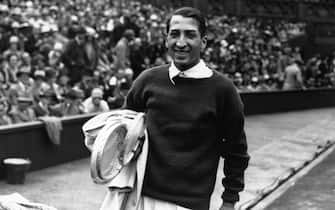 6th July 1928:  French tennis player Rene Lacoste smiles after winning the Men's Single Final against Henri Cochet at Wimbledon.  (Photo by Davis/Topical Press Agency/Getty Images)