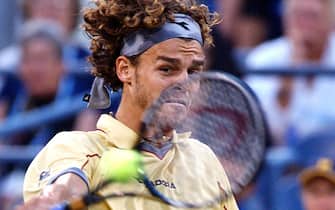 FLUSHING MEADOWS, UNITED STATES:  Number one seeded Gustavo Kuerten of Brazil makes a backhand return to unseeded Albert Costa of Spain at the US Open in Flushing Meadows, New York, 04 September 2001.  AFP PHOTO/Stan HONDA (Photo credit should read STAN HONDA/AFP via Getty Images)