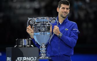 Serbia's Novak Djokovic celebrates with the ATP number 1 player trophy after winning to Norway's Casper Ruud during their single match of ATP Finals' first round at the Pala Alpitour venue in Turin on November 15, 2021. (Photo by Marco BERTORELLO / AFP) (Photo by MARCO BERTORELLO/AFP via Getty Images)