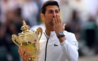 Novak Djokovic with the trophy after beating Roger Federer in the mens singles final on day thirteen of the Wimbledon Championships at the All England Lawn Tennis and Croquet Club, Wimbledon.