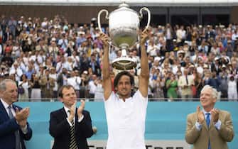 epa07668614 Spain's Feliciano Lopez (2-R) lifts his trophy after defeating Gilles Simon of France in their final match at the Fever Tree Championship at Queen's Club in London, Britain, 23 June 2019.  EPA/WILL OLIVER