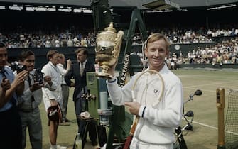 (Original Caption) Wimbledon, England: Rod Laver flashes a winning smile as he holds the loving cup high after defeating fellow Australian Tony Roche 6-3, 6-4, 6-2, for the men's singles title at Wimbledon July 5th. It was Laver's third Wimbledon title and the first win for a professional in the prestigious tournament.
