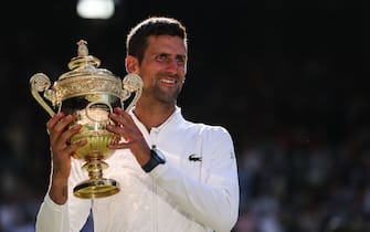 Serbia's Novak Djokovic poses with his trophy afterdefeating Australia's Nick Kyrgios during the men's singles final tennis match on the fourteenth day of the 2022 Wimbledon Championships at The All England Tennis Club in Wimbledon, southwest London, on July 10, 2022. - RESTRICTED TO EDITORIAL USE (Photo by Adrian DENNIS / AFP) / RESTRICTED TO EDITORIAL USE (Photo by ADRIAN DENNIS/AFP via Getty Images)