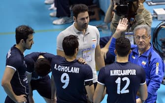 epa03960722 Argentina born Julio Velasco (R), coach of Iran, leads his players during the FIVB Men's World Grand Champions Cup volleyball match against Russia at Tokyo Metropolitan Gymnasium in Tokyo, Japan, 22 November 2013. Russia won the match.  EPA/FRANCK ROBICHON