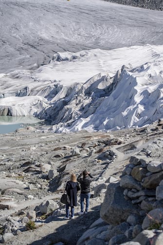 SWITZERLAND NATURE ALPS epa08553193 People visit the Rhone Glacier covered in blankets above Gletsch near the Furkapass in Switzerland, 18 July 2020. The Alps oldest glacier is protected by special white blankets to prevent it from melting. EPA/URS FLUEELER