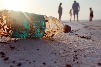 PENSACOLA, FL - JUNE 06:  A plastic bottle is seen coated in oil on Pensacola Beach as oil makes its way on shore from the Deepwater Horizon oil spill in the Gulf of Mexico on June 6, 2010 in Pensacola, Florida. Early reports indicate that BP's latest plan to stem the flow of oil from the site of the Deepwater Horizon incident may be having some sucess.  (Photo by Joe Raedle/Getty Images)