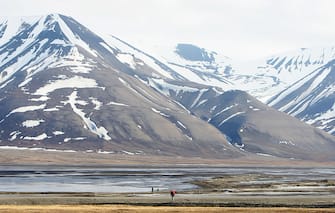 LONGYEARBYEN, NORWAY - JUNE 21:  A lone walker sets out from the town of Longyearbyen during Midsummer on June 21, 2008 in Longyearbyen, Norway. Longyearbyen is the seat of Norwegian local administration in Svalbard, 620 miles south of the North Pole. It was founded in 1906 by the American John Munroe Longyear who started coal mining here, something that has been an important part of the history ever since. Three important mines currently work on Svalbard. Longyearbyen was only opened for general tourism in 1990 and is a haven for eco-tourists who come to see the abundant polar bears, seals and whales. Svalbard consists of a group of islands ranging from 74' to 81' North, and 10' to 35' East, thus making it the northernmost part of Norway. It boasts the world's northernmost Church, Museum and higher education facilities.  (Photo by Chris Jackson/Getty Images)