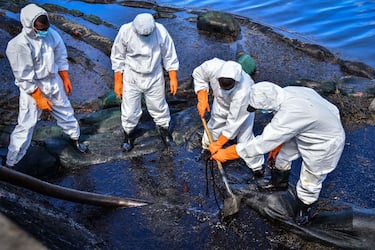 TOPSHOT - Volunteers collect leaked oil from the MV Wakashio bulk carrier that had run aground at the beach in Bois des Amourettes, Mauritius, on August 13, 2020. - Mauritius avoided a second catastrophic oil spill on August 12, 2020, after salvage crews pumped the remaining fuel from the tanks of a cargo ship that ran aground off its coast, imperilling world-famous wildlife sanctuaries. (Photo by Beekash Roopun / L'Express Maurice / AFP) (Photo by BEEKASH ROOPUN/L'Express Maurice/AFP via Getty Images)
