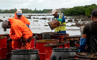 Workers collect leaked oil at the beach in Riviere des Creoles on August 15, 2020, due to the oil leaked from vessel MV Wakashio, belonging to a Japanese company but Panamanian-flagged, that ran aground near Blue Bay Marine Park off the coast of south-east Mauritius. - A fresh streak of oil spilled on August 14, 2020, from a ship stranded on a reef in pristine waters off Mauritius, threatening further ecological devastation as demands mount for answers as to why the vessel had come so close to shore. (Photo by Fabien Dubessay / AFP) (Photo by FABIEN DUBESSAY/AFP via Getty Images)