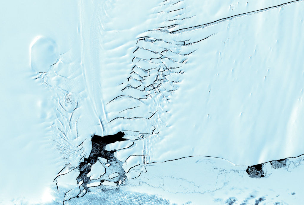 1185488274 This image taken 12 December 2000 and released by NASA 22 March 2001 shows a crack (Upper L) on Pine Island glacier is also seen by the ASTER instrument, on board the TERRA satellite. At its widest point, the crack is 400-500 meters across. Scientists believe that the crack appeared rapidly, less than five weeks, and would begin calving icebergs in approximately 18 months. On the left hand side of the image, stress fractures in the ice are clearly seen. AFP PHOTO (Photo by - / NASA / AFP) (Photo by -/NASA/AFP via Getty Images)